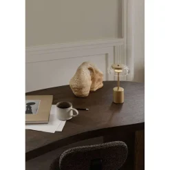 Nuura LED-batteridrevet bordlampe Blossi, højde 26 cm, guldfarvet/klar