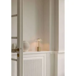 Nuura LED-batteridrevet bordlampe Blossi, højde 26 cm, guldfarvet/klar